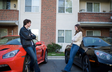 roommates leaning against their cars in the driveway of their apartment image generated by Grok AI